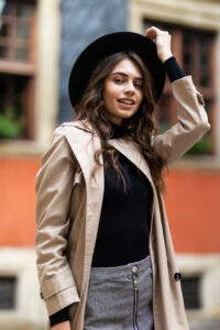 outdoor fashion portrait of glamour sensual young stylish lady wearing trendy fall outfit and black hat on the street